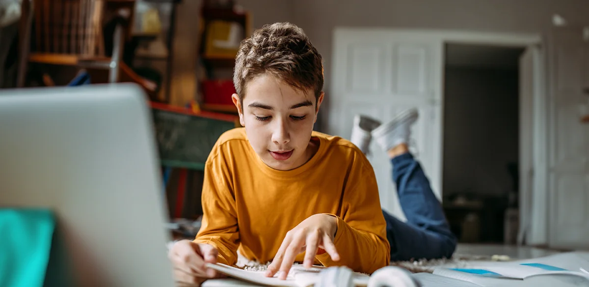 Student taking notes at home